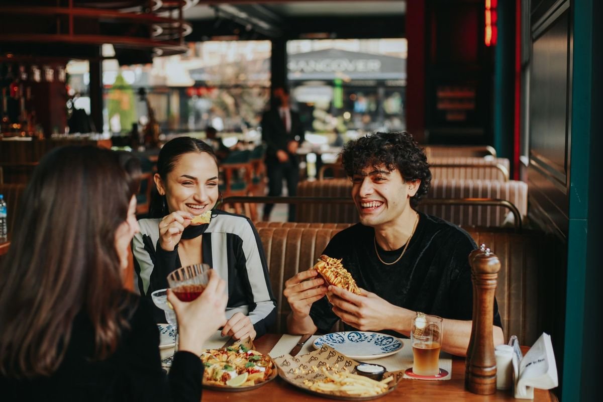 Des clients rient autour d'une table de restaurant