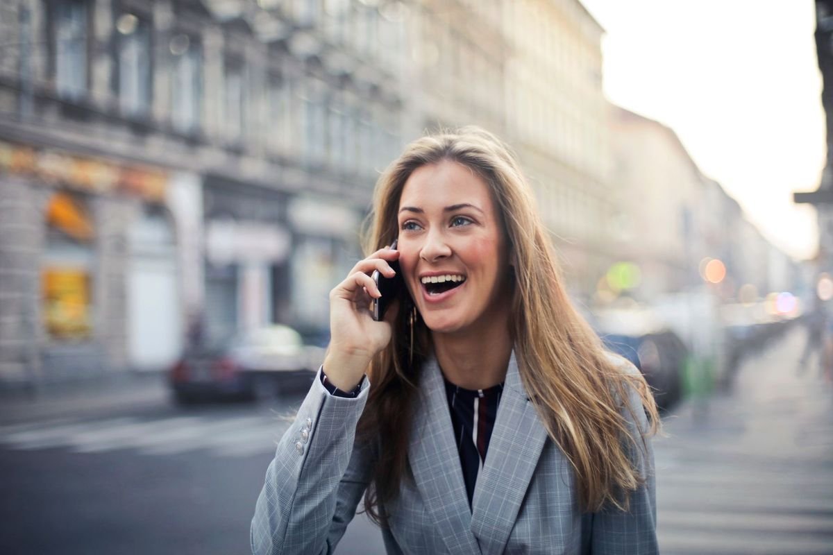 Une cliente appelle en souriant depuis la rue